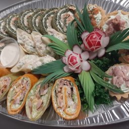 CATERING TRADYCJA PATRYCJA JASIŃSKA - Elegancka srebrna taca z różnorodnymi przekąskami: roladki szpinakowe, muszle makaronowe z farszem, tortille z nadzieniem i mini tartaletki z kremem i łososiem, udekorowane rzodkiewkami w kształcie...