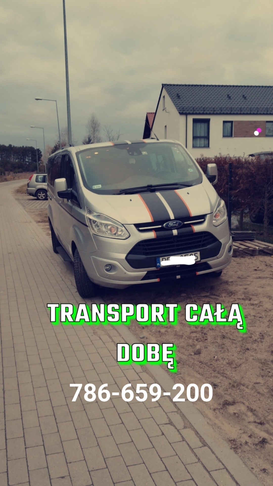 Srebrny bus Ford Transit z czarno-pomarańczowymi pasami na masce i dachu, zaparkowany na chodniku z kostki, widoczny numer telefonu kontaktowego.
