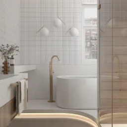 Minimalistyczna łazienka z białymi płytkami, wolnostojącą wanną i złotą armaturą, oświetlona wiszącymi lampami kulami i podświetleniem podłogowym, z widokiem na miejską zabudowę za oknem.