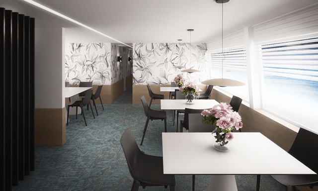 Wnętrze kawiarni z kwiatowym motywem na ścianie, nowoczesne lampy wiszące, białe stoliki i czarne krzesła, widok na morze za oknem.