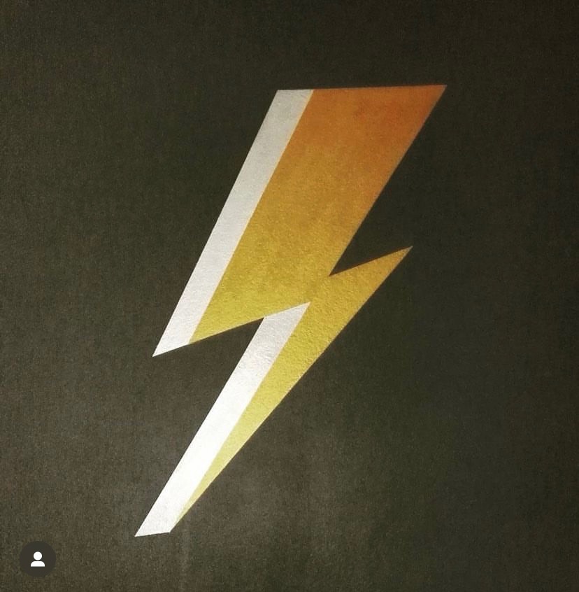 Żółto-biały symbol błyskawicy na ciemnoszarym tle, wykonany techniką malarską z widoczną teksturą farby.
