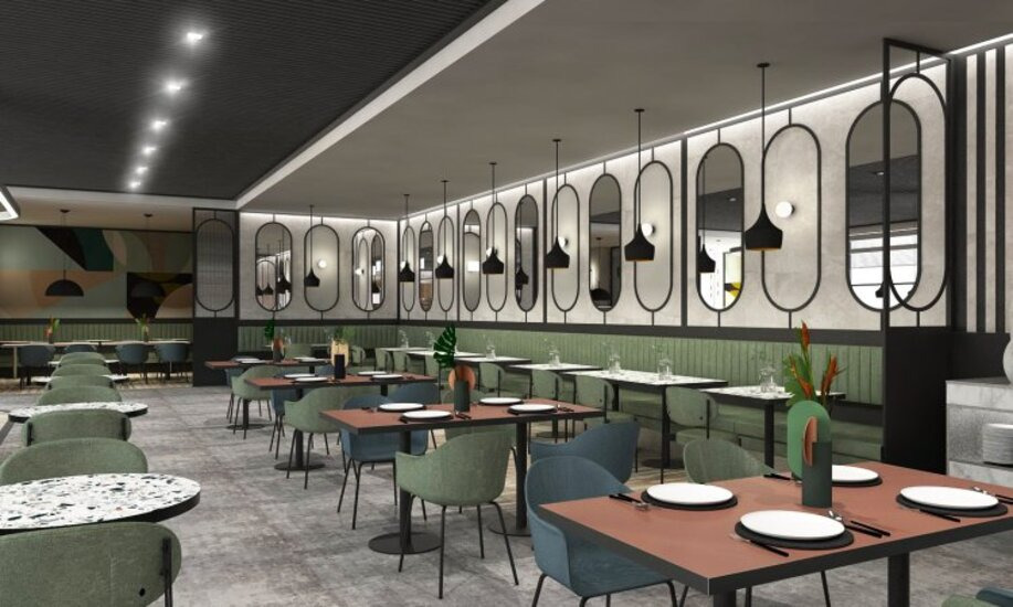 Wnętrze nowoczesnej restauracji z rzędem stolików nakrytych białymi talerzami, zielonymi krzesłami i dekoracyjnymi lustrami w czarnych ramach na ścianie.