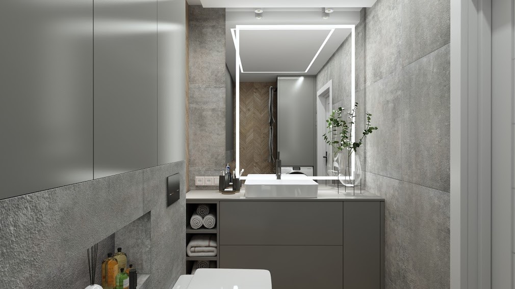 Nowoczesna łazienka w odcieniach szarości z podświetlanym lustrem, umywalką nablatową i zabudową meblową z otwartymi półkami na ręczniki.