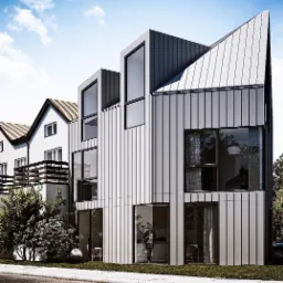 Nowoczesny dom w Kazuniu Polskim z elewacją i dachem pokrytym blachą na rąbek stojący, sąsiadujący z tradycyjnym budynkiem.