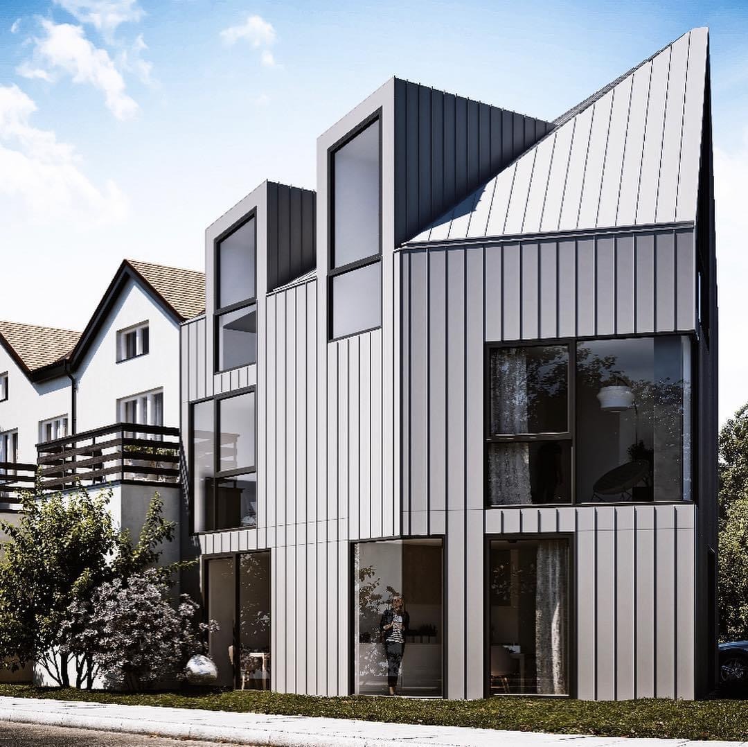 Nowoczesny dom w Kazuniu Polskim z elewacją i dachem pokrytym blachą na rąbek stojący, sąsiadujący z tradycyjnym budynkiem.