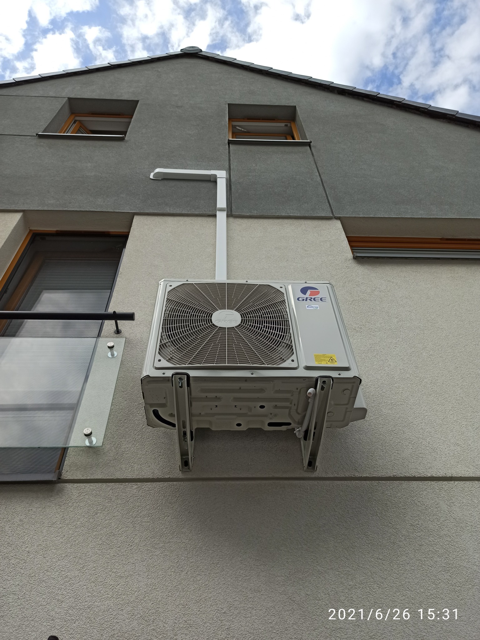 Klimatyzator Gree zamontowany na elewacji budynku we Wrocławiu, widoczny z perspektywy żabiej, z fragmentem balkonu po lewej stronie.