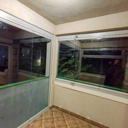 Junior Construction - Szklana zabuda balkonu NPV, ta po lewej z piaskowabymu szybami do połowy dająca efekt mlecznej powłoki