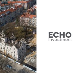 SAM Agencja Fotograficzna - Zdjęcie z lotu ptaka przedstawia budynek w trakcie renowacji, otoczony tymczasowym ogrodzeniem, z widocznym logo 'ECHO investment' po prawej stronie.