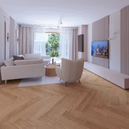 Jasne, przestronne wnętrze salonu z parkietem w jodełkę, kominkiem i telewizorem. Stonowana kolorystyka, minimalistyczny design. Widok na zieleń za oknem.