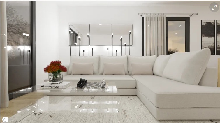 Jasny salon z narożną sofą, szklanym stolikiem kawowym z szachami, kwiatami w wazonie i dekoracyjnymi lustrami na ścianie.