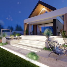 Zielona Posesja - Nowoczesny ogród nocą: minimalistyczny dom, oświetlone schody, palenisko, designerski fotel i starannie dobrane rośliny w donicach. Wizualizacja.