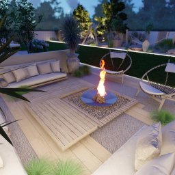 Zielona Posesja - Wieczorny taras z paleniskiem, drewnianym podestem i wygodnymi sofami. Oświetlenie LED podkreśla roślinność i meble ogrodowe. Relaksująca atmosfera.