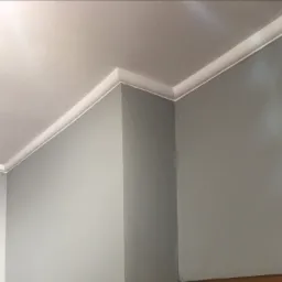 Szare ściany i biały sufit połączone ozdobnym białym paskiem, widok z dołu.