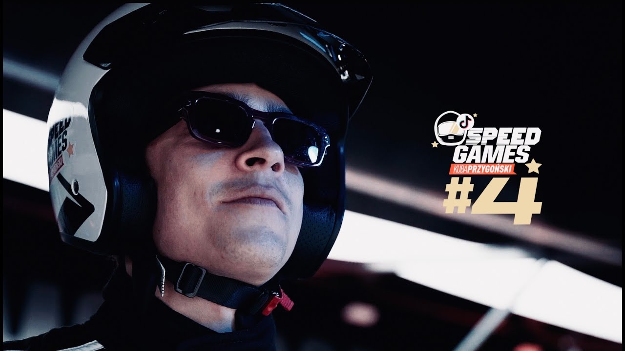 Portret mężczyzny w kasku i okularach przeciwsłonecznych, z logo 'Speed Games' w tle, sugerujący udział w nagraniach filmowych.