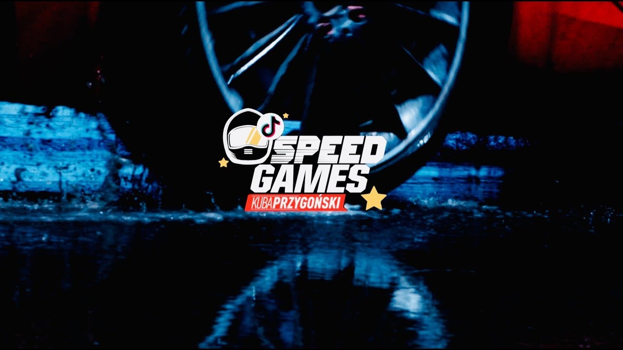 Logo Speed Games Kuba Przygoński z elementami graficznymi koła samochodowego i refleksami na mokrej powierzchni, utrzymane w ciemnej kolorystyce z akcentami niebieskiego i czerwonego.
