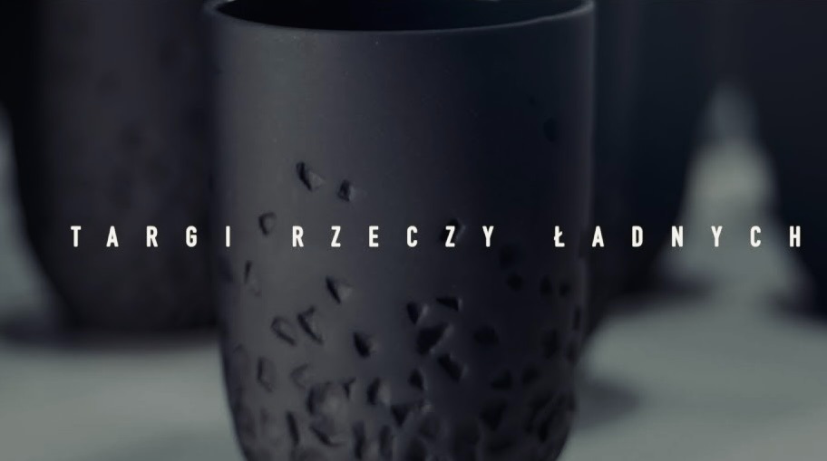 Prezentacja czarnych, matowych kubków z wyżłobieniami na tle napisu 'Targi Rzeczy Ładnych' przez firmę z Rzeszowa, uchwycona w minimalistycznym stylu.
