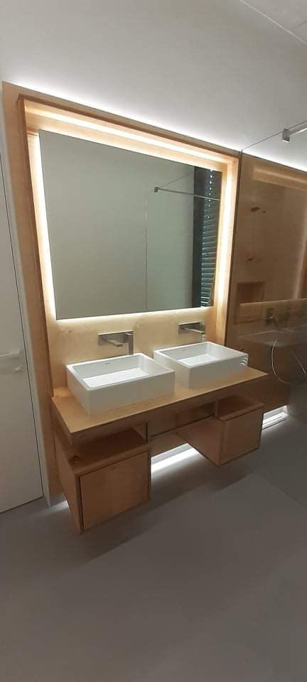 Nowoczesna łazienka z dwoma kwadratowymi umywalkami nablatowymi, drewnianą szafką z oświetleniem LED i dużym lustrem z podświetleniem, minimalistyczne baterie.