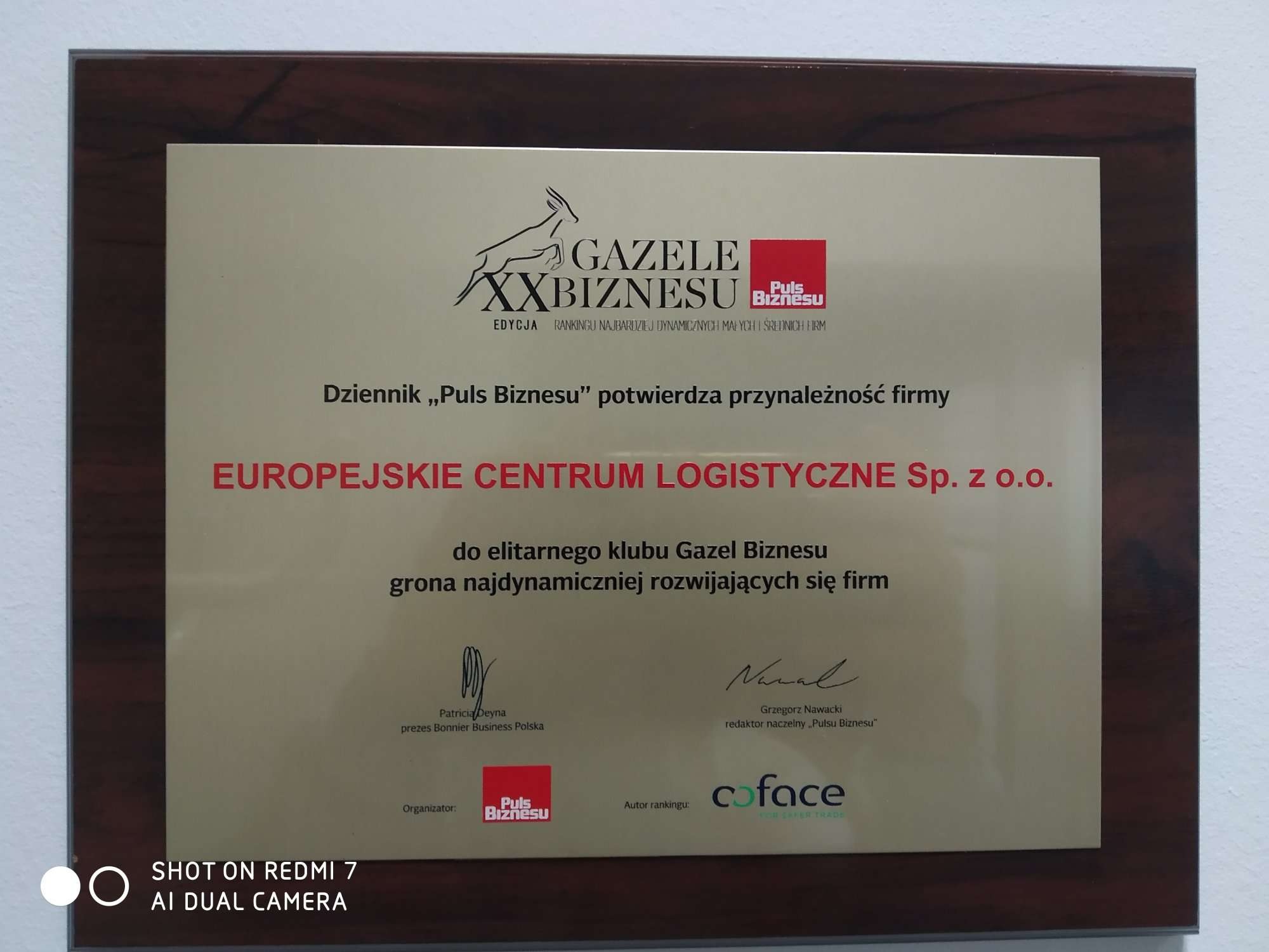 Dyplom Gazele Biznesu w drewnianej ramce, przyznany firmie Europejskie Centrum Logistyczne Sp. z o.o., potwierdzający przynależność do grona najdynamiczniej rozwijających się firm, z podpisami...
