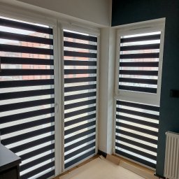 GRZEGORZ PYĆ ATOS-SERWIS ROLET - Trzy okna z zamontowanymi roletami typu dzień i noc, widok z wnętrza mieszkania, podłoga zabezpieczona kartonem podczas montażu.