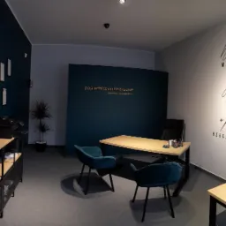 Nowoczesne biuro doradcy finansowego z turkusowymi fotelami, drewnianym biurkiem i ścianą z napisem 'Dzisiaj marzenia, jutro plany, pojutrze rzeczywistość'.