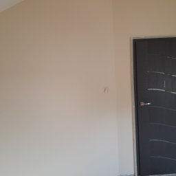 Bad Bud - Świeżo pomalowane wnętrze z beżowymi ścianami, nowa, ciemnoszara, wewnętrzna stolarka drzwiowa z poziomymi, dekoracyjnymi wstawkami ze szkła; zabezpieczona folią podłoga w trakcie prac...