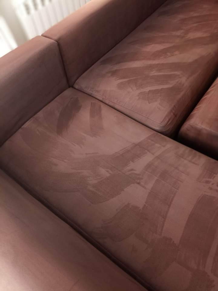 Fragment narożnika z welurową tapicerką w odcieniach różu, widoczne ślady po czyszczeniu na mokro.