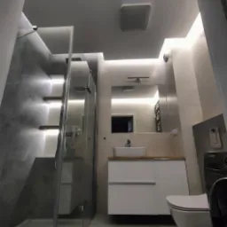 Nowoczesna łazienka z podświetlaną kabiną prysznicową typu walk-in, umywalką nablatową na białej szafce z drewnianym blatem, wiszącą toaletą i ukrytym oświetleniem LED.