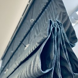 Royal Firany - Szara roleta rzymska z wzorem w paski, widok od dołu, z widocznymi sznurkami i elementami montażowymi.