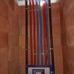 Instalacja podtynkowa WC Geberit Sigma z doprowadzonymi rurami PEX w kolorach czerwonym i niebieskim, przymocowanymi do ściany z cegły dziurawki metalowymi uchwytami.