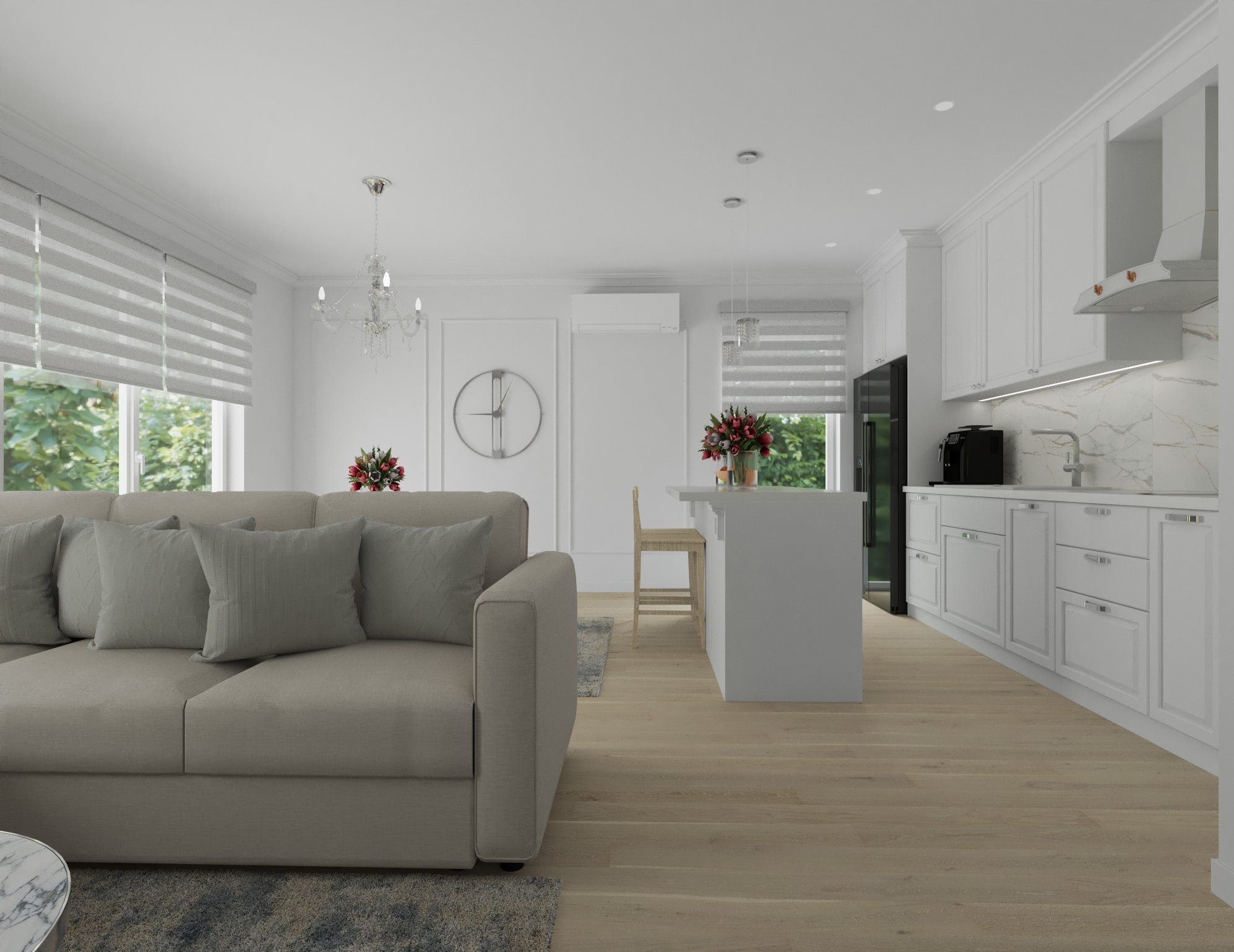Jasne, przestronne wnętrze: beżowa sofa z poduszkami, biała kuchnia z wyspą, drewniana podłoga, dekoracyjny zegar na ścianie i żyrandol.