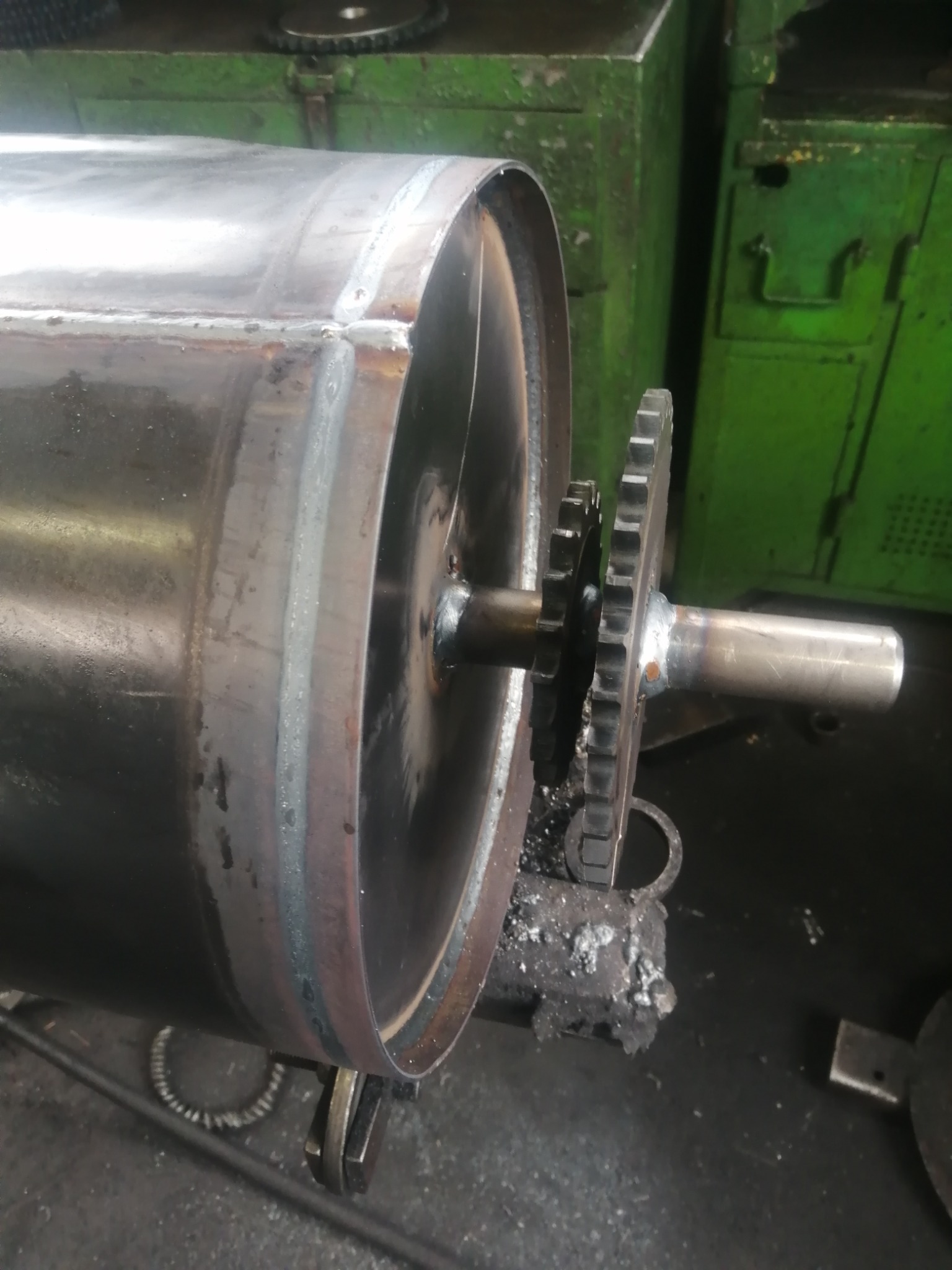 Surowy, metalowy cylinder z przyspawaną zębatką w warsztacie w Zamościu, widoczne ślady spawania i obróbki.