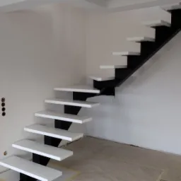 Wnętrze w trakcie wykańczania z nowoczesnymi schodami wspornikowymi o białych stopniach i czarnej konstrukcji nośnej, widoczne przygotowania do montażu podłogi.