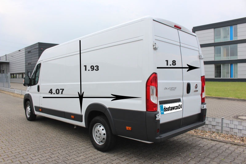 Biały furgon dostawczy Fiat Ducato z naniesionymi wymiarami: długość 4.07m, wysokość 1.93m i szerokość tylnych drzwi 1.8m, zaparkowany na zewnątrz budynku przemysłowego.