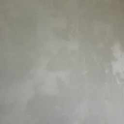 Szara, gładka ściana z efektem delikatnego cieniowania, wykonana techniką dekoracyjną. Widoczna struktura i subtelne przejścia tonalne. Minimalistyczny design.