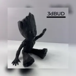 Czarna figurka Baby Groot wydrukowana w 3D, siedząca na białym tle, z widocznym logo firmy 3dBUD w tle.