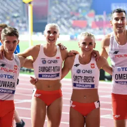 Czterech uśmiechniętych lekkoatletów w strojach reprezentacji Polski, pozujących razem po zawodach w Doha 2019, z widocznymi nazwiskami Suwara, Baumgart-Witan, Święty-Ersetic i Omelko na koszulkach.