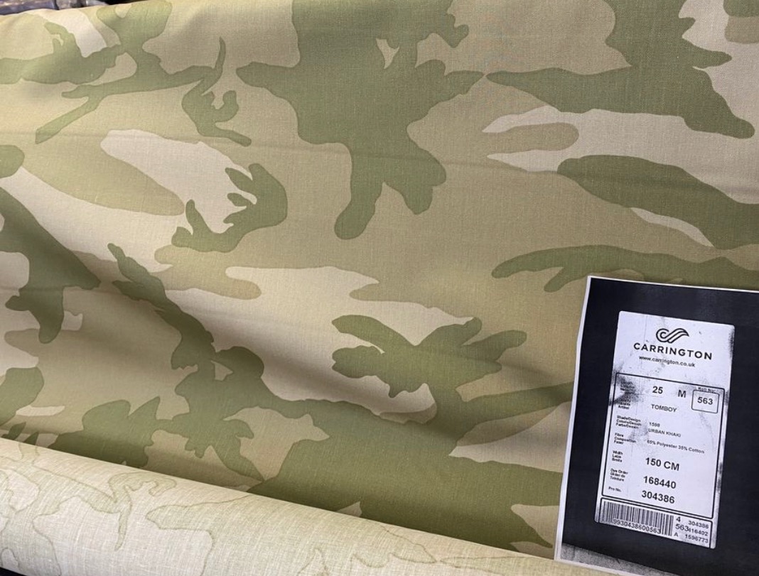 Rolka tkaniny w kamuflażu khaki z etykietą producenta Carrington, widoczne numery seryjne i specyfikacja składu.