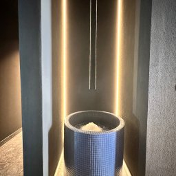 PINA Montaż Sp.z o.o - Stylowa, mozaikowa balia z lodem w strefie spa, podświetlona pionowymi lampami. Minimalistyczny design, chłodna kolorystyka, nowoczesne wykończenie.