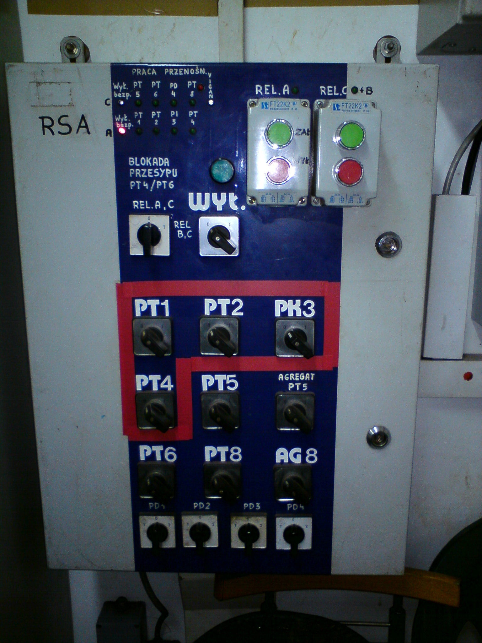 Panel sterowania z przełącznikami, przyciskami i diodami, oznaczony symbolami PT1-PT8, AG8, PD1-PD4, REL.A, REL.C+B, z widocznymi napisami informacyjnymi i schematami, w przemysłowym otoczeniu.