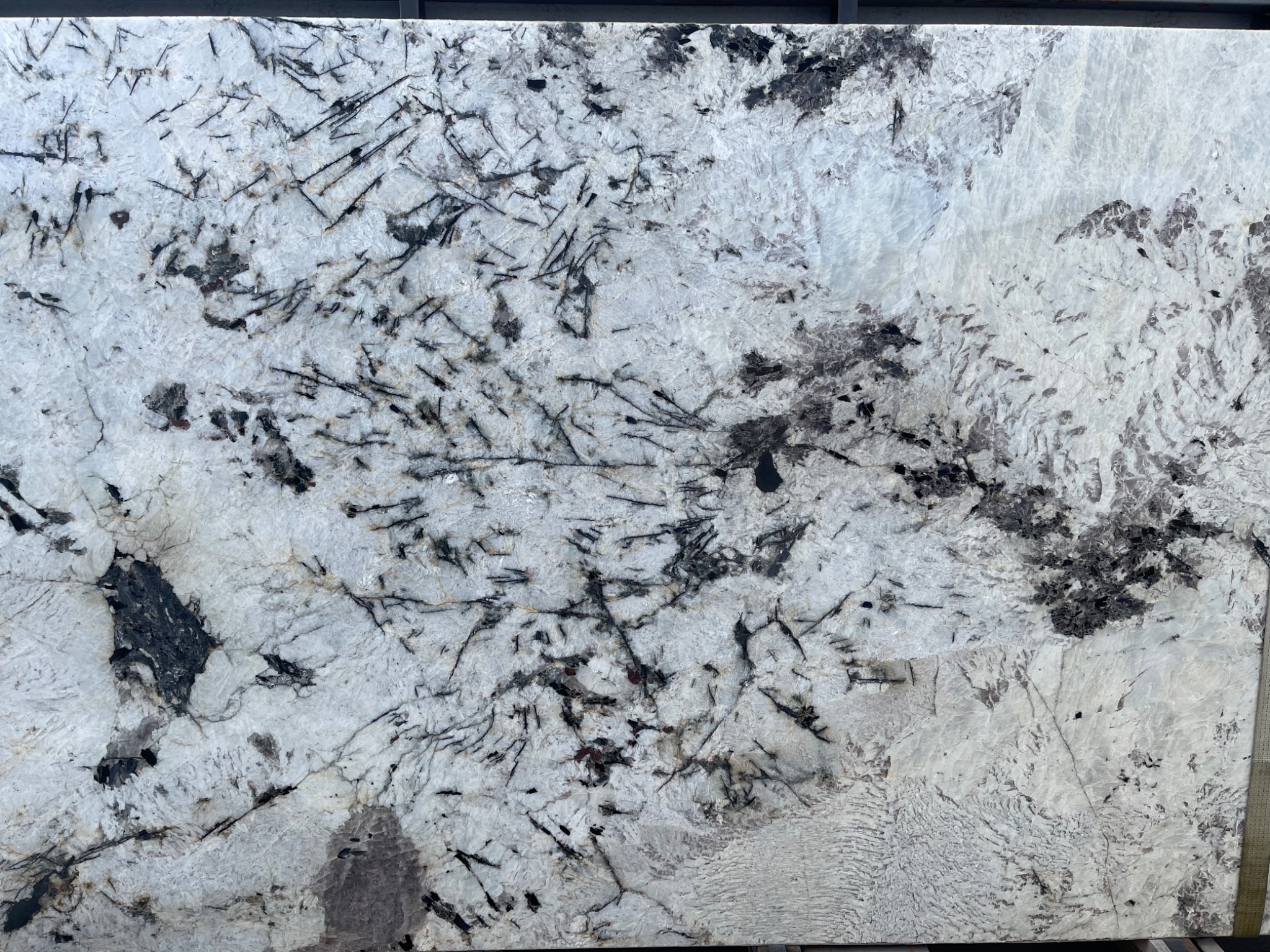 Płyta kwarcu brazylijskiego z wyraźnym, nieregularnym wzorem czarnych i białych żył, prezentowana w hurtowni kamienia.