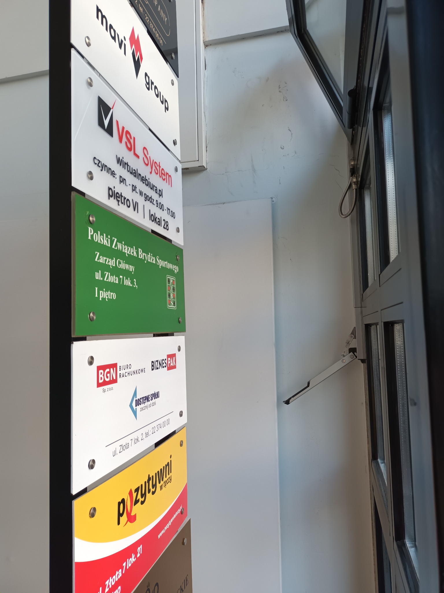 szyldy wielu firm w wejściu do kamienicy ul. Złota 7 w Warszawie - wirtualne biuro VSL-System ul. Złota 7 lok. 28 Warszawa