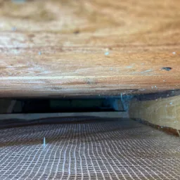 Drewniana konstrukcja z widoczną siatką wzmacniającą, prawdopodobnie przygotowana pod ocieplenie.