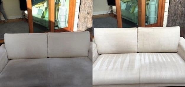 Beżowa sofa z widoczną różnicą w czystości: lewa część przed, prawa po czyszczeniu, widoczne smugi po czyszczeniu na prawej stronie, w tle okno z drewnianą ramą.