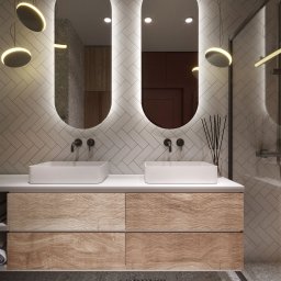 ASPEKT ARCHITEKTURA ANETTA SALA - Nowoczesna łazienka z podwójną umywalką nablatową, drewnianą szafką z szufladami, podświetlanymi lustrami owalnymi i płytkami ułożonymi w jodełkę na ścianie, oświetlenie punktowe.
