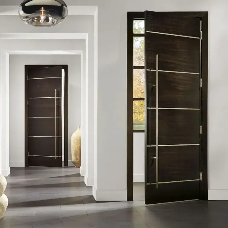 Nowoczesne, ciemne drzwi wewnętrzne z metalowymi akcentami, częściowo otwarte, widok z perspektywy korytarza z podobnymi drzwiami w tle. Minimalistyczny design.