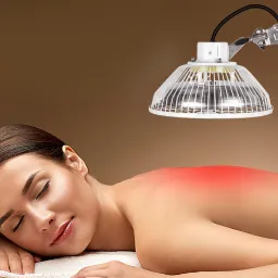 Kobieta leżąca na brzuchu pod lampą nagrzewającą plecy, z widocznym zaczerwienieniem skóry.