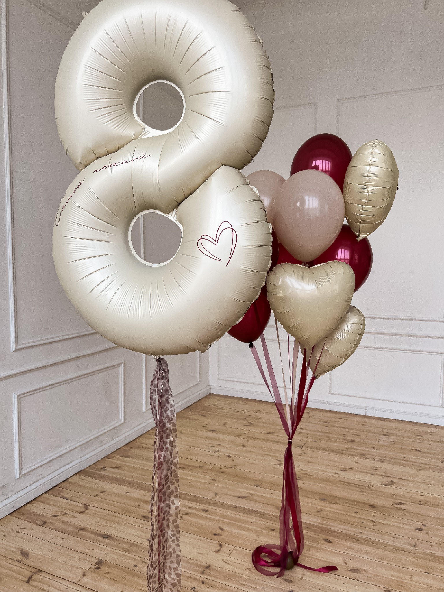 Zestaw balonów na ósmą rocznicę, w odcieniach beżu i bordo, z dekoracyjnymi wstążkami i napisem na jednym z balonów w kształcie cyfry.