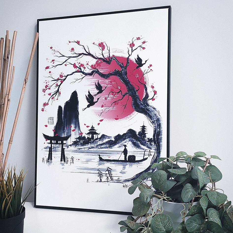 Oprawiony w czarną ramę plakat z ilustracją w stylu japońskim: drzewo wiśni, czerwone słońce, pagody, góry i łódka z rybakiem, obok bambus i doniczka z rośliną.