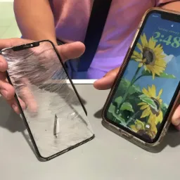 Smartfon z rozbitym ekranem obok sprawnego telefonu z tapetą słonecznika, prezentowane w Krakowie.