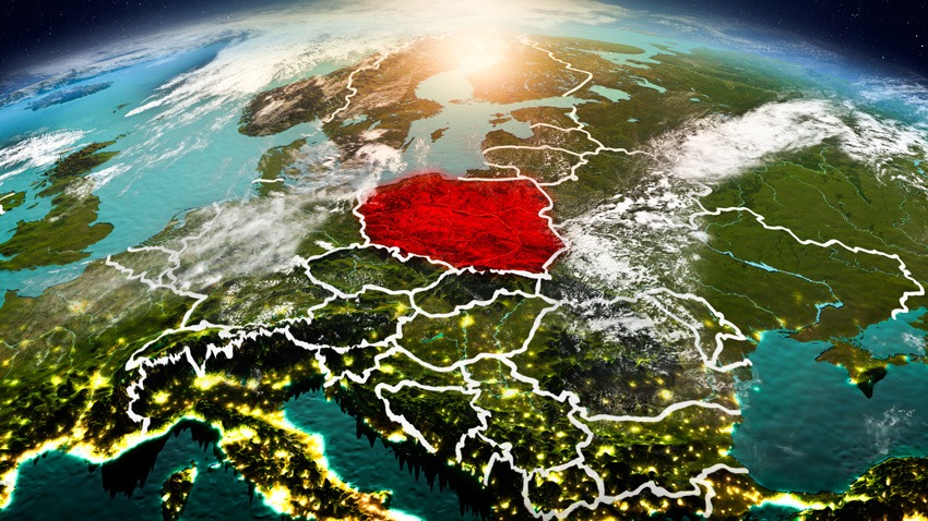 Mapa Europy z kosmosu, z wyraźnie zaznaczoną Polską na czerwono, oświetloną wschodzącym słońcem, widoczne granice państw.